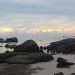 A serene scene of a beach abroad that shows a tranquil landscape to encourage calm thoughts in stressful times, helping professionals navigate career transitions.